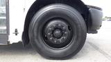 A close-up of a black tire from a 2015 International PC105 bus with visible lug nuts and a smooth tread pattern