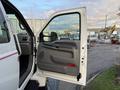 A white 2006 Ford F-650 with its driver's side door open showing the interior door panel and handle