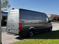 A 2021 Mercedes-Benz Sprinter van in a gray color with a high roof and side cargo doors parked on a street