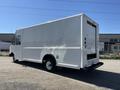 A 2012 Ford Econoline truck with a plain white exterior and a boxy design featuring a large open rear cargo area