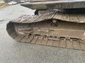 Close-up of a muddy track on a 2006 Hitachi ZX200LC excavator showing the treads and undercarriage detail