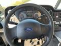 Steering wheel and dashboard of a 2011 Ford Econoline showing gauges and controls