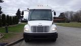 A white 2013 Freightliner M2 106 bus facing forward with a large windshield and multiple front lights