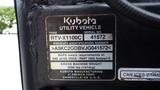 A 2018 Kubota RTV X1100C utility vehicle with a metal identification plate displaying the serial number and manufacturing details