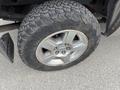 A close-up of a wheel and tire from a 2013 Chevrolet Silverado Hybrid showcasing a silver alloy rim and rugged tread pattern