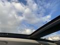 View of the open sunroof of a 2015 Fiat 500L showcasing a blue sky with clouds visible through the opening