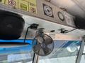 Interior view of a 2012 Ford Econoline featuring a metal dashboard with control panels a small fan and speakers mounted above the windshield