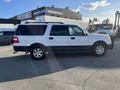 A white 2013 Ford Expedition with a black lower body and five-spoke wheels parked on a lot