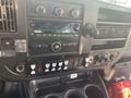 The interior dashboard of a 2018 Chevrolet Express featuring a radio display climate controls and various buttons for vehicle functions