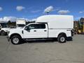 A white 2019 Ford F-350 Super Duty with a high cargo cap and four-wheel drive parked on a lot