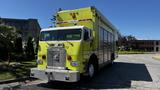 A bright yellow 1995 Freightliner FLL086 with a prominent front grill and multiple compartments on the side