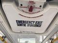 Emergency exit sign inside a 2017 Chevrolet Express with instructions in English and French to open the hatch and a warning not to open the hatch