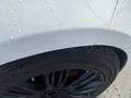 Close-up of a white 2020 Land Rover Range Rover Sport showing a black alloy wheel and a portion of the vehicle's body wet with water droplets