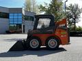 A 2017 Gehl R105 skid steer loader in profile view showing its orange and black design and front loader attachment