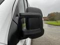 Close-up of a side mirror on a white 2018 RAM Promaster with raindrops on its surface