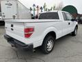 A white 2010 Ford F-150 pickup truck with a standard cab bed and good tires viewed from the rear right angle