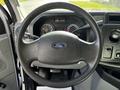 A 2019 Ford Econoline steering wheel with the Ford logo visible and various dashboard instruments in the background