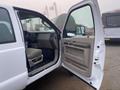 A 2009 Ford F-450 SD with its front driver's side door open revealing the beige interior and dashboard