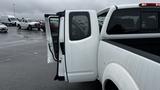 A 2016 Nissan Frontier with an open rear door showcasing the interior of the cab