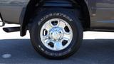 A chrome wheel and tire from a 2014 RAM 3500 displaying Bridgestone Dueler H/T tire branding on the sidewall