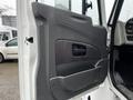 Interior door panel of a 2011 International DuraStar 4300 featuring a black and textured design with a handle and armrest