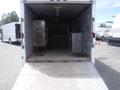 A 2010 Forest River Enclosed trailer with an open rear ramp revealing an empty interior featuring metal surfaces and storage compartments