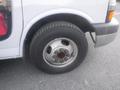 Close-up of the wheel and tire of a 2016 Chevrolet Express showing a silver hubcap and black tire with visible tread