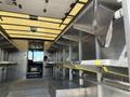 Interior view of a 2011 Ford Econoline van with metal shelving and a driver's area visible in the background