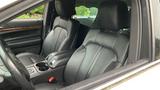 Interior view of a 2013 Lincoln MKT showing black leather front seats with armrests and a center console with cup holders