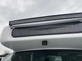 Close-up of the top of a white 2012 Chevrolet Express with a light bar and a covered area above the windshield