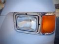 Close-up of the headlight of a 2006 Ford F-650 with clear glass and an orange turn signal light