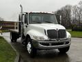 A 2011 International DuraStar 4300 truck with a white cab and chrome grille parked on a wet surface