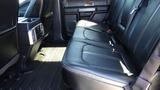 Interior view of the back seat of a 2017 Ford F-350 SD featuring black leather upholstery and a floor mat