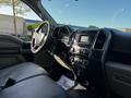 Interior view of a 2017 Ford F-150 showing the dashboard steering wheel and control panel with a black leather seat.