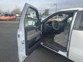 A 2009 Ford F-150 with the driver's door open revealing beige interior and steering wheel