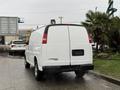 A white 2009 Chevrolet Express van parked with its rear view visible showcasing a clean design and no visible license plate