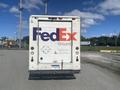 A 1999 Ford Econoline delivery truck with the FedEx Ground logo prominently displayed on its rear door