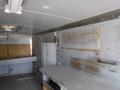 Interior view of a 2010 Forest River Enclosed trailer featuring bare walls with wooden paneling and a worktable in the center