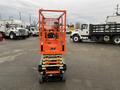 An orange JLG R1932 scissor lift with a raised platform and safety guardrails designed for aerial work and construction tasks