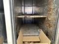 A 2010 Ford F-550 empty cargo area with metal shelves and a cardboard box on the floor