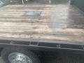 A 2015 Chevrolet Silverado 3500HD truck bed with a wooden floor and a circular metal accessory cover in the center