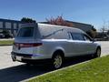 A silver 2013 Lincoln MKT hearse parked on the street with a polished exterior and a distinctive elongated body designed for transporting caskets