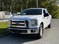 A white 2017 Ford F-150 pickup truck is parked, featuring a chrome grille and alloy wheels, with a spacious cab and bed design