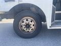 A close-up of a tire on a 1999 Ford Econoline showing the wheel rim and tread details