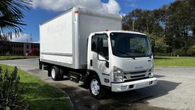 2016 Isuzu NPR box truck with a white exterior and Budget branding parked on a lot