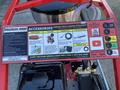 A red Magnum 4000 Hot Water Pressure Washer featuring various accessories listed on a panel including rotary nozzles hose reels sandblast kits and drain cleaning kits