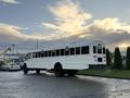 A 2015 International 3000 school bus with a white exterior parked on a roadway