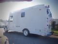 A white 2006 Freightliner FS65 vehicle with a large cargo area and various light fixtures on top