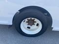 A close-up view of a white wheel with a rusted hub and a black tire from a 2007 Freightliner MT55