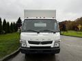 A 2012 Mitsubishi Fuso FE with a white box truck body and clear headlights facing directly forward